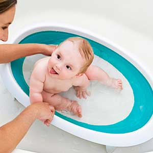 baby being washed in fold up bathtub