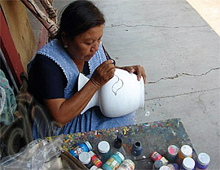 Artist painting clay vessel